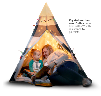 Mother and son in a tent with a string of lights reading
